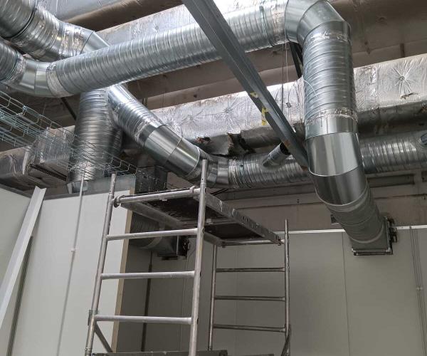 Installation de système de ventilation sur un toit plat pour améliorer la circulation de l'air dans un bâtiment professionnel.